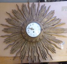 An early 20thC carved giltwood cased sunburst wall clock; the movement faced by a convex white