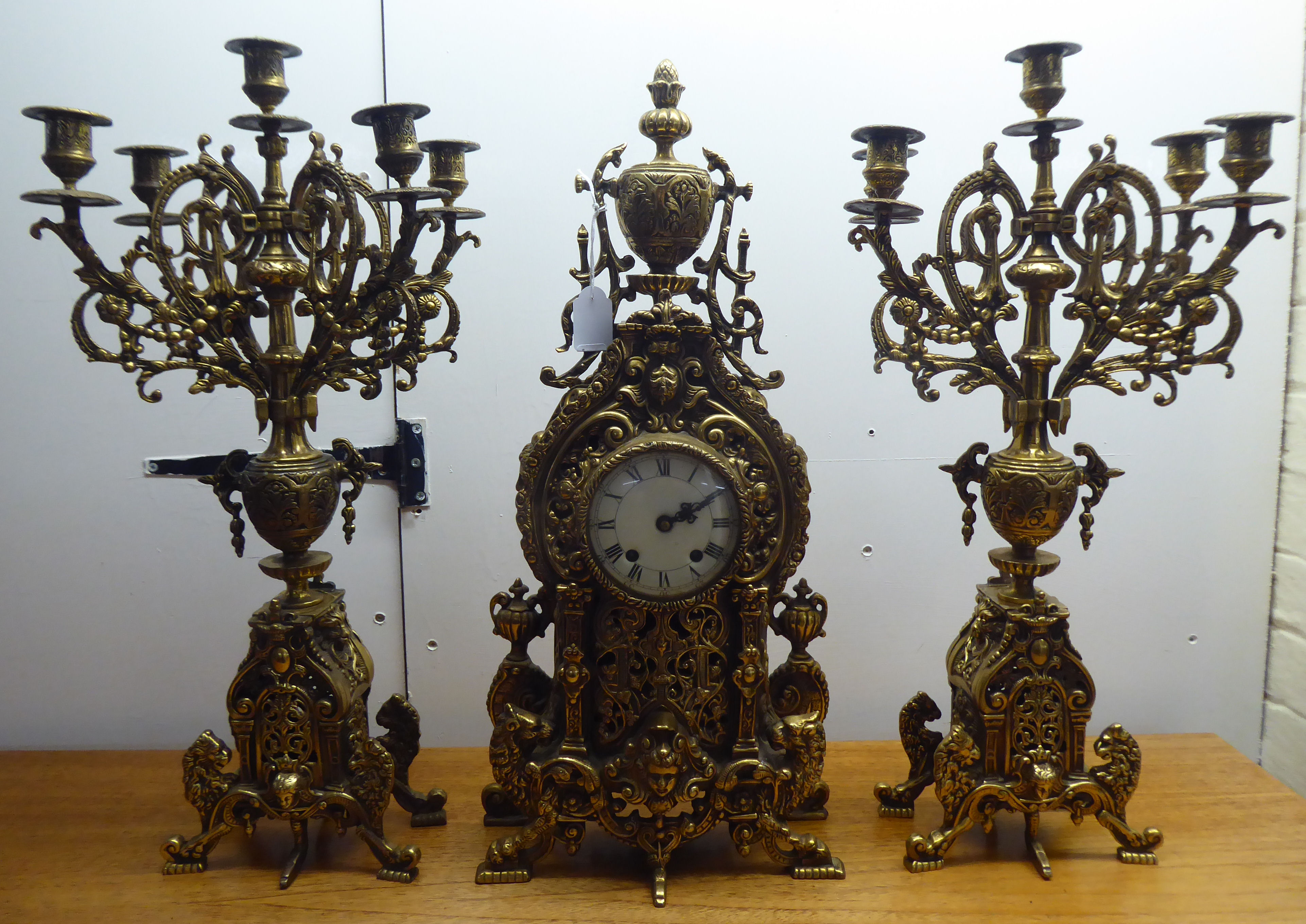 A mid 20thC mantel clock, the brass case profusely decorated in Empire style; the 8 day movement