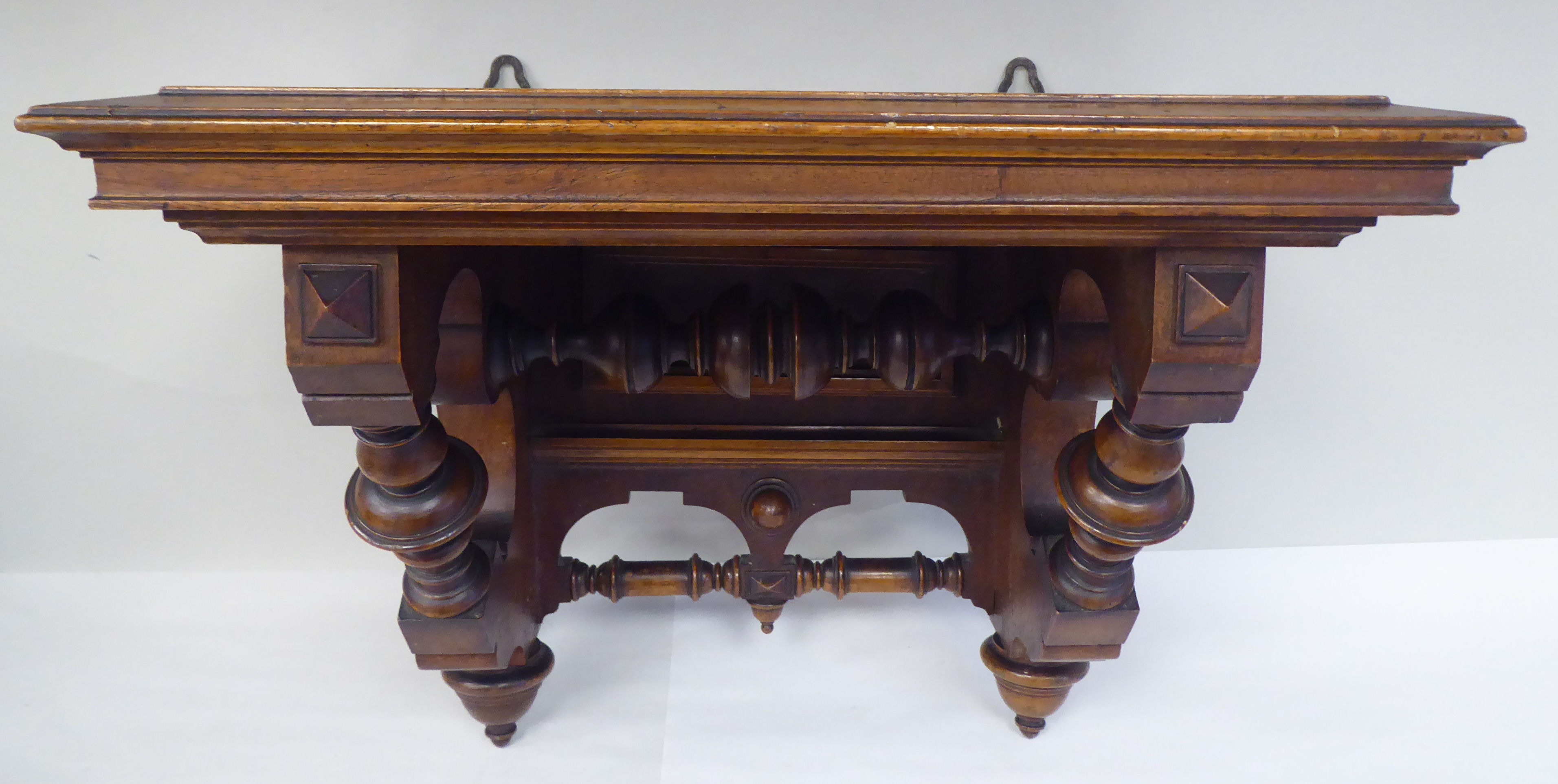 A late Victorian walnut clock bracket, the platform top over a series of elaborately turned supports