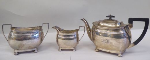A three piece silver tea set of oval, bulbous form, on bun feet, comprising a teapot with a swept