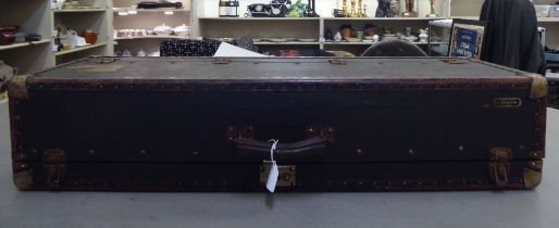 A black faux hide covered salesman's trunk with metal bracket supports  37"w