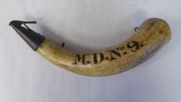 A powder horn with an applied metal dispensing mechanism, inscribed MD No.9  12"L overall