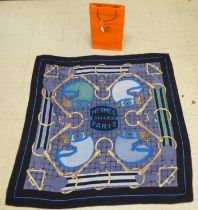 A Hermes silk and wool scarf, designed by H D'Origny  48"sq in a Hermes bag