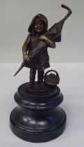 A cast and patinated bronze figure, a little girl carrying an adult's umbrella, on a turned wooden