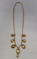 A yellow metal necklace, set with a graduated group of oval cut yellow citrine