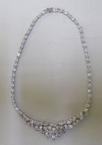 A silver necklace, set with multiple white stones
