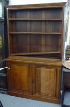 An Edwardian mahogany cabinet bookcase, the superstructure with three open shelves, over a pair of