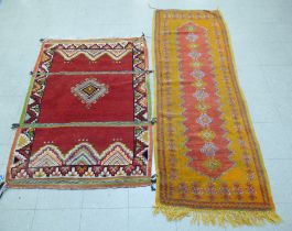 Rugs: to include an Afghan example with geometric motifs, on an orange ground  39" x 64"