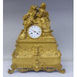 A 19thC French gilt metal cased mantel clock, featuring a seated couple, on a draped cushion, the