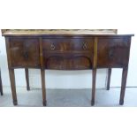 An early 20thC Georgian design mahogany serpentine front serving sideboard with two central drawers,