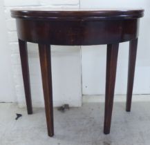 A George III mahogany demi-lune tea table, the hinged top raised on square, tapered legs  28"h  31"w