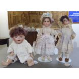 Three bisque head dolls: to include an early 20thC example with painted features, on a jointed