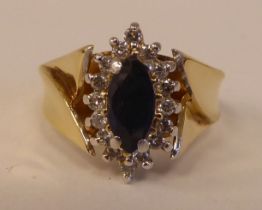 A 14ct gold ring, set with a sapphire and diamond, surrounded by small claw set diamonds