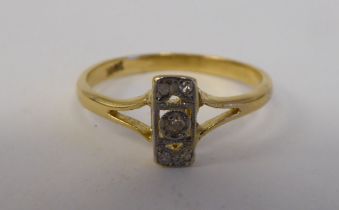 A yellow metal ring, set with five diamonds, arranged on a central bar  stamped 18ct