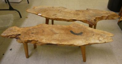 Two rustically constructed elm coffee tables of natural form, raised on tapered legs  15"h  48"w &