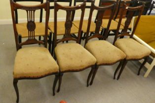 A set of four Edwardian mahogany framed salon chairs, each with a splat back and upholstered seat,