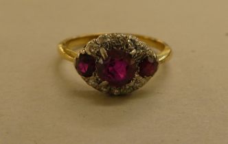 A yellow metal ring, set with diamonds and red stones