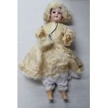 An early 20thC Max Oscar Arnold Welsch bisque head doll with painted features, on a jointed