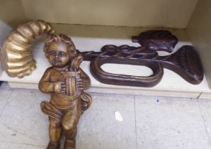 Four carved and painted decorative wooden artefacts: to include a cherubic figure with a harp  19"h