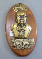 A commemorative brass door knocker, celebrating the life of Winston Churchill, attached to an oval