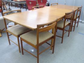 A McIntosh teak dining table, raised on tapered legs  30"h  64"L; and a matching set of six chairs