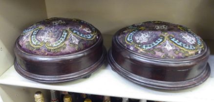 A pair of 19thC stained and turned mahogany framed footstools, on ball feet, respectively set with