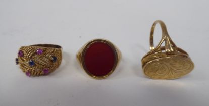 Three 9ct gold variously designed dress rings: to include one set with amethyst and ruby coloured