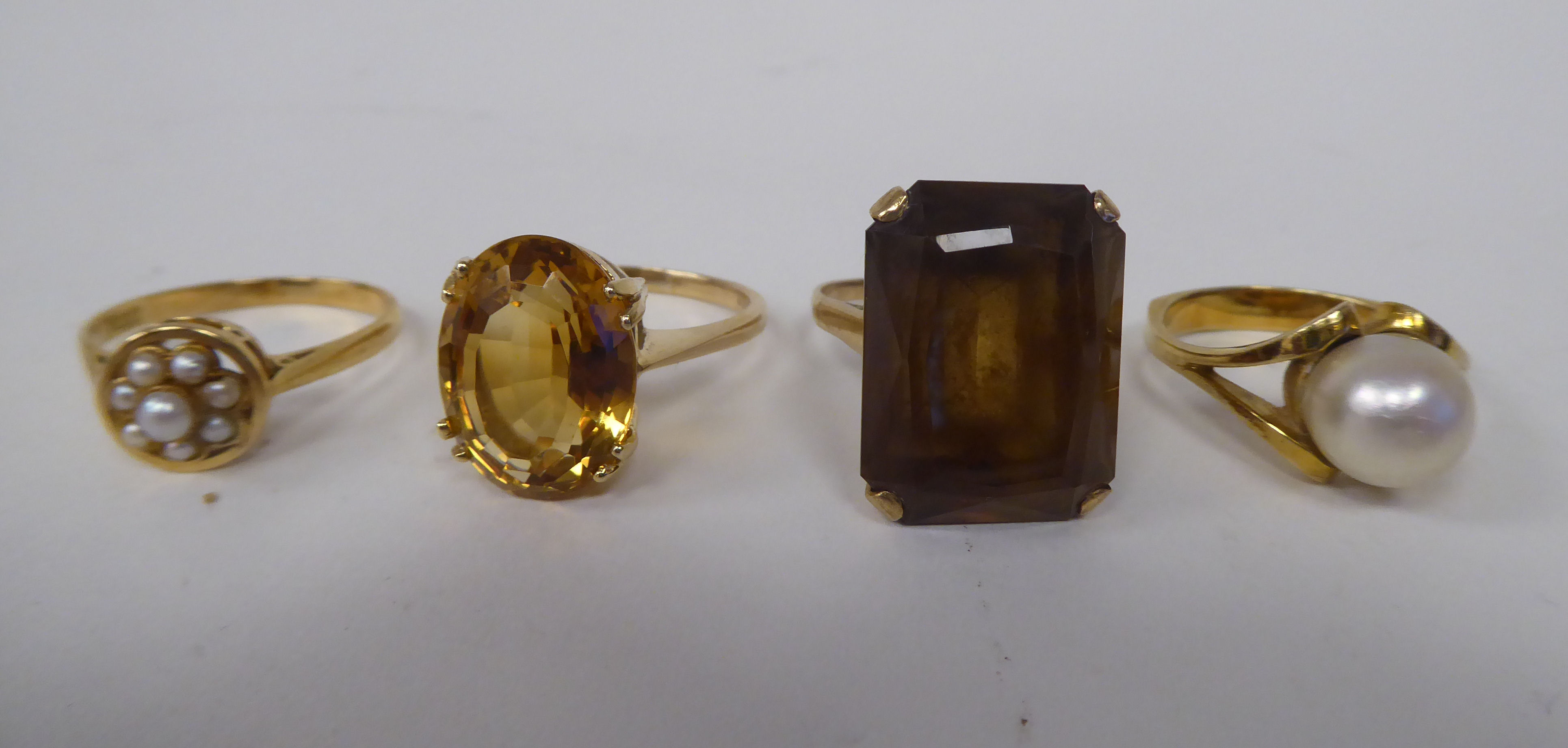 Four various 9ct gold and other dress rings, one claw set with a citrine