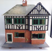 A 20thC scratch built doll's house, fashioned as a faux brick Tudor inspired home with front