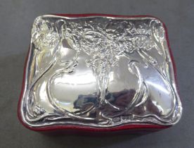 A moulded red fabric covered jewellery box with an applied silver plaque to the lid in Art Nouveau