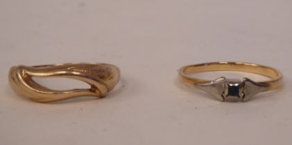 A yellow metal ring of flowing design; and another, set with a single coloured stone