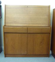 A modern teak bureau, the fall flap enclosing a blotter and pigeon holes, over two drawers and two