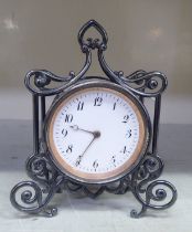 A late Victorian silver cased mantel timepiece of drum design, in an ornately scrolled wire frame;