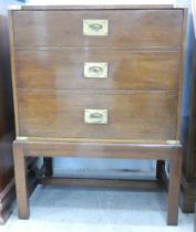 A modern military design, brass bound mahogany cabinet with a facsimile three drawer front with a