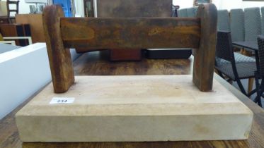 A rust coloured cast iron boot scraper, on a stone plinth  9"h  15"w