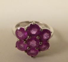 A white metal cluster ring, set with seven pink sapphires  stamped 925