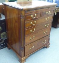 A modern mahogany facsimile dressing chest with a rise-and-slide action, raised on bracket feet