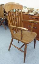 A late Victorian beech and elm framed spindle back chair, raised on turned legs