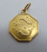 An 18ct gold pendant, decorated with a pair of fish, amidst stars  stamped 750