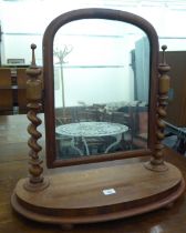 A late Victorian mahogany dressing table mirror, the plate pivoting on barleytwist uprights, on a