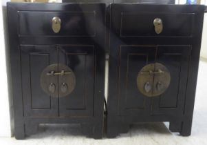A pair of modern Japanese inspired black painted bedside chests, each with a single drawer, over two