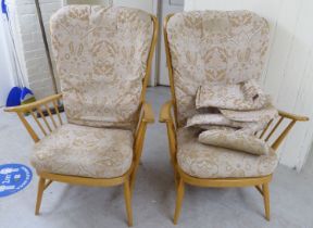 A pair of Ercol high back blonde beech and elm framed, spindled open arm chairs with loose fabric