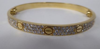 A Cartier style 18ct gold diamond set 'Love' style bangle  stamped 750