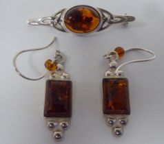 A pair of silver and amber bead set pendant earrings; and a matched brooch