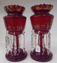 A pair of late 19thC gilded and overpainted ruby coloured glass lustre vases, the bowls with