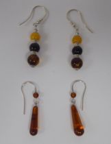 Two similar pairs of silver coloured metal, multi-coloured amber bead set pendant earrings