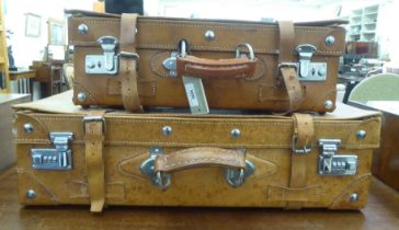 Two stitched brown hide suitcases  6.5"h  19"w and 7"h  24"w