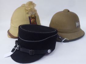 A Royal Welsh Fusiliers, Hawkes & Co khaki coloured pith helmet and liner; a similar German