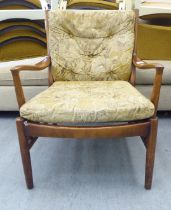 A vintage Parker Knoll, stained beech framed fireside armchair, raised on turned legs and stretchers