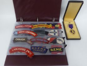 A miscellaneous collection of military embroidered uniform badges and titles, some copies: to